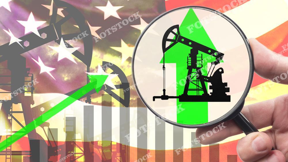 На изображении показан рост нефтяной индустрии США через графический символ зеленой стрелки вверх. На переднем плане увеличительное стекло с изображением нефтяного насоса, на заднем фоне — флаг США. Иллюстрация отражает подъем добычи нефти и ее значение для экономики страны.